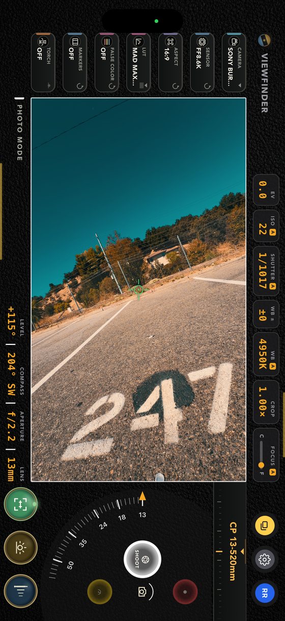 The viewfinder with the phone held upright on a road — a tall frame filling the screen, the readouts running down the sides, at 13mm